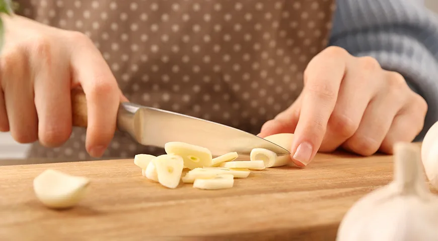 Per asciugare in un'asciugatrice elettrica, tagliare gli spicchi d'aglio a fettine sottili.